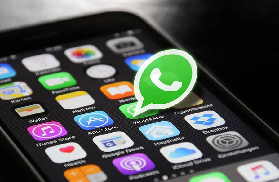 Celular com a tela aberta em vários logos de aplicativos com o simbolo do WhatsApp em destaque
